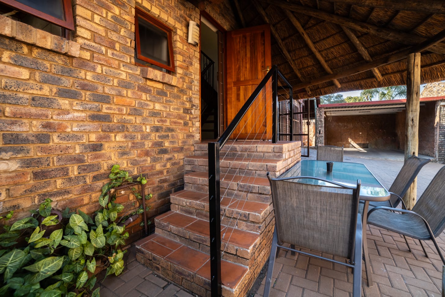 Comfortable guest accommodation at Thatch Haven featuring African-inspired wall art and a rustic headboard.