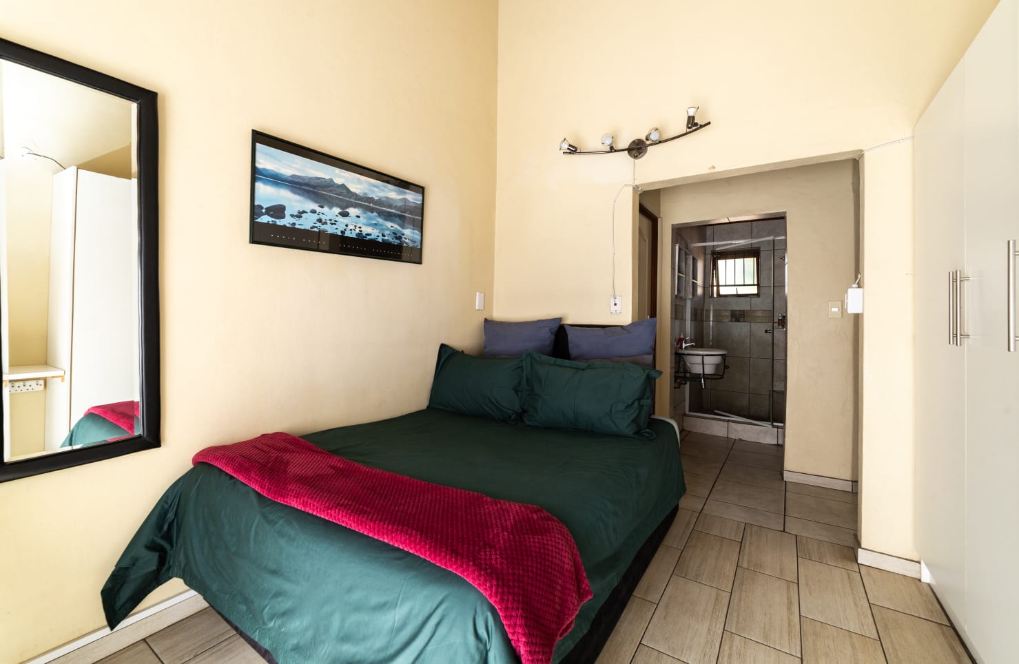Guest room amenities including a wall-mounted TV, bar fridge, microwave, and desk for a comfortable stay.