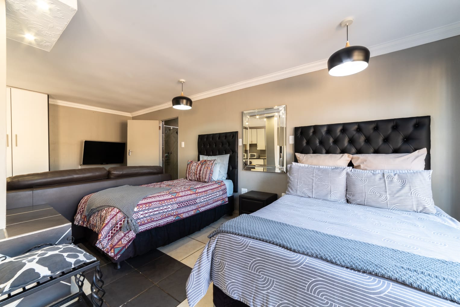 Comfortable guest accommodation at Thatch Haven featuring African-inspired wall art and a rustic headboard.
