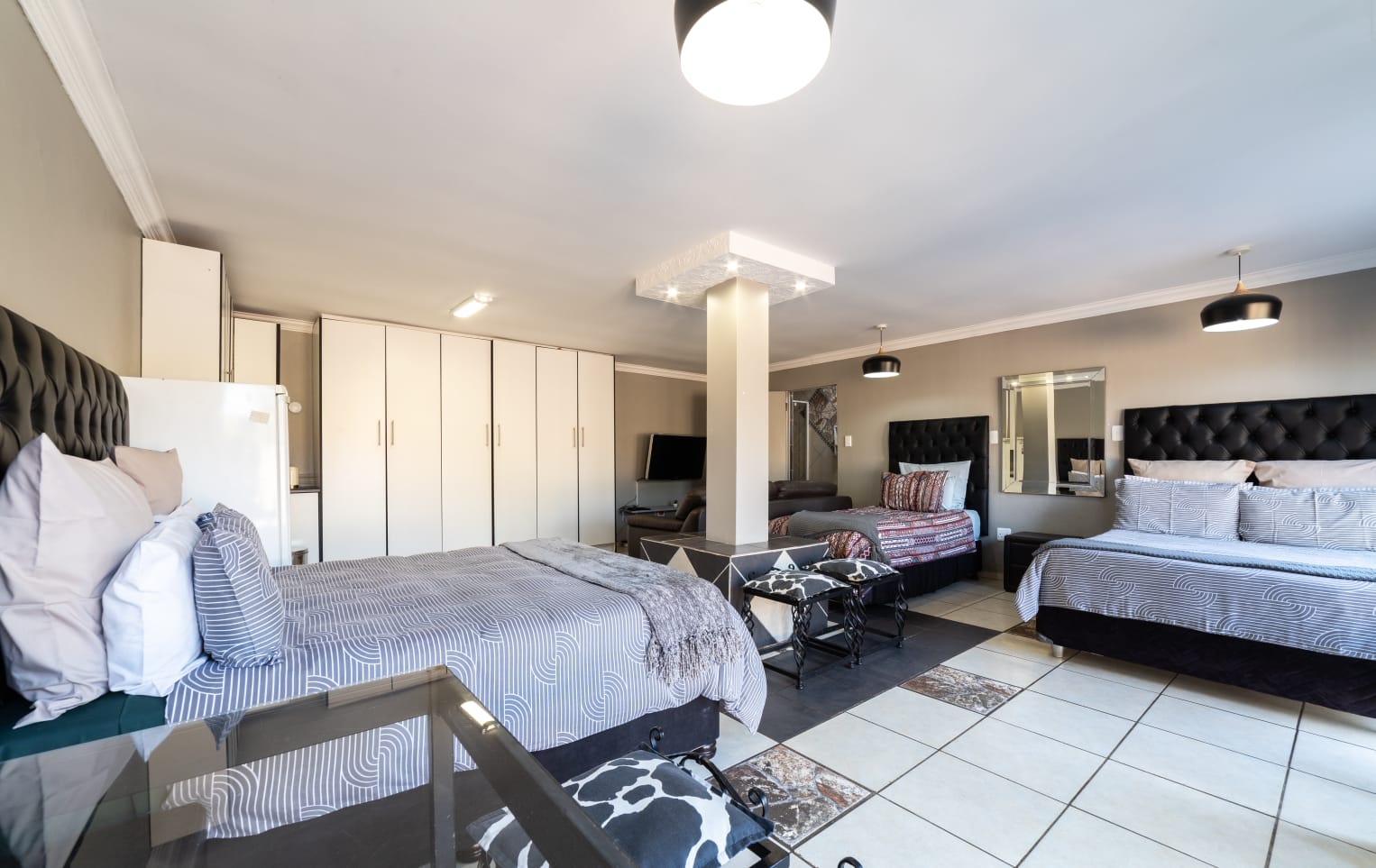 Guest room amenities including a wall-mounted TV, bar fridge, microwave, and desk for a comfortable stay.